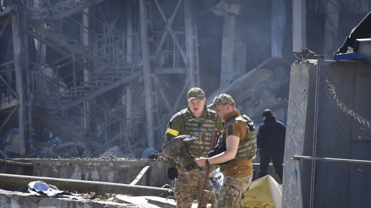 Soldados ucranianos nos escombros de um edifício após um bombardeamento da Rússia
