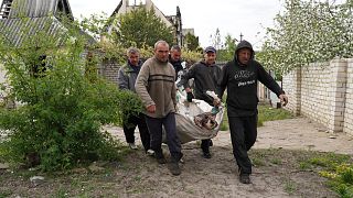 Volunteers exhume the bodies of civilians killed by Russian shelling in the village of Stepaky, close to Kharkiv, Ukraine, Wednesday, May 11, 2022