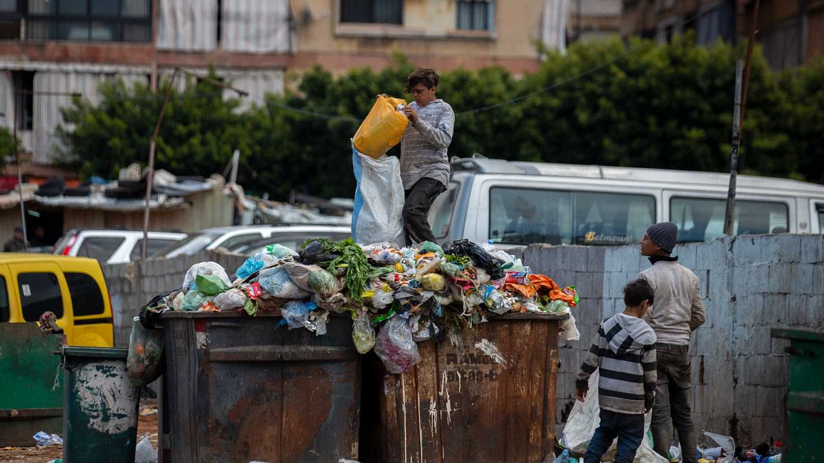 أطفال يبحثون عن الأشياء الثمينة في القمامة المجاورة لسوق في بيروت، لبنان، الاثنين 12 أبريل / نيسان 2021