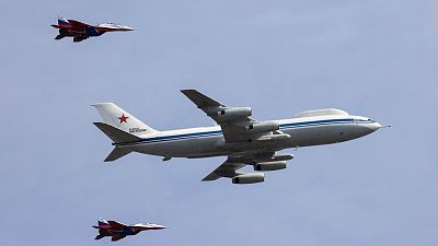 A Russian Il-80 military transport aircraft, also known as the Doomsday plane, and MiG-29 fighter jets fly in formation during a rehearsal for a flypast.