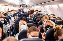 Passengers departing from Amsterdam's Schiphol airport, wearing masks.
