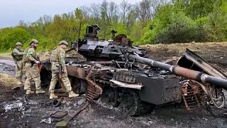 Tropas junto a un tanque destrozado