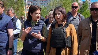 Ukrainian Prosecutor General Iryna Venediktova, left, talks with German Foreign Minister Annalena Baerbock as they stand near a mass grave in Bucha, near Kyiv.