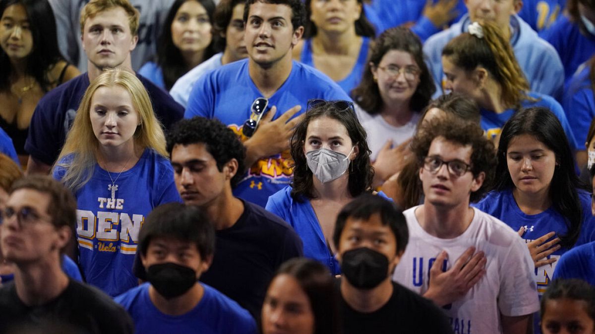 Estudiantes universitarios escuchan el himno nacional durante un partido de voleibol en Los Ángeles, EEUU
