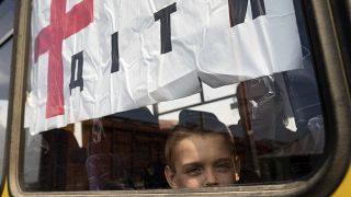 A boy from Siversk looks though the window of a bus during evacuation near Lyman, Ukraine, Wednesday, May 11, 2022. (AP Photo/Evgeniy Maloletka)