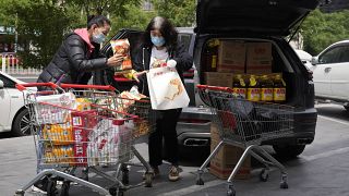 Zwei Frauen in Peking erledigen einen Großeinkauf.