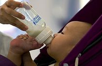 Μωρό πίνει το γάλα του σε μπιμπερό - φώτο αρχείου