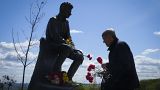 A man lays flowers at an Unknown Soldier Tomb to mark Victory Day in World War II, in Kyiv, Ukraine, Monday, May 9, 2022, as the Russian attack on Ukraine continues.