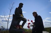 A man lays flowers at an Unknown Soldier Tomb to mark Victory Day in World War II, in Kyiv, Ukraine, Monday, May 9, 2022, as the Russian attack on Ukraine continues.