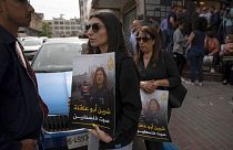 فلسطينيون يحملون لافتات وصور لشيرين أبو عاقلة تقول "شيرين صوت فلسطين"، أمام مكتب قناة الجزيرة في مدينة رام الله بالضفة الغربية.