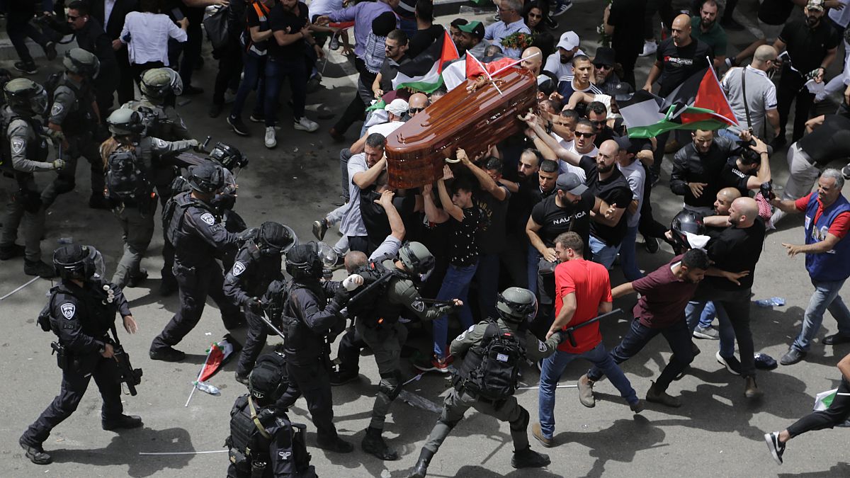 Israeli police confront with mourners as they carry the casket of slain Al Jazeera veteran journalist Shireen Abu Akleh during her funeral in east Jerusalem, May, 13, 2022.