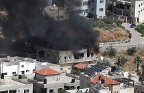 دخان يتصاعد من مبنى في مدينة جنين بالضفة الغربية في 13 مايو 2022 خلال غارة عسكرية إسرائيلية.