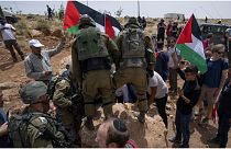 القوات الإسرائيلية تمنع نشطاء سلام فلسطينيين وإسرائيليين من تحريك حجر يسد طريقًا يمر بالقرب من مستوطنة مزبي يائير اليهودية الإسرائيلية، مسافر يطا، 13/05/2022 الضفة الغربية