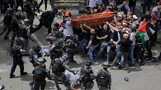 Israeli police confront with mourners as they carry the casket of slain Al Jazeera journalist Shireen Abu Akleh during her funeral in east Jerusalem, Friday, May 13, 2022