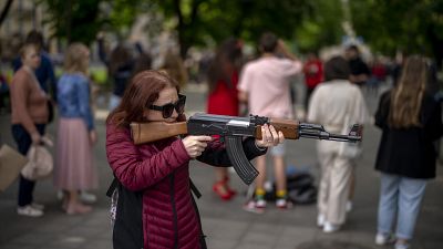 سيدة أوكرانية تحكل بندقية كلا شينكوف بلاستيكية
