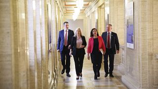 Pat Finucane, Michelle O'Neil, Mary Lou McDonald et Conor Murphy, membres du Sinn Fein, traversent les couloirs du Parlement, à Stormont, à Belfast, le 9 mai 2022