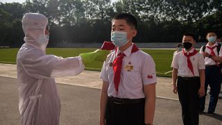 قياس درجة حرارة طالب كجزء من إجراءات مكافحة كوفيد-19 في مدرسة بيونغ يانغ الثانوية، كوريا الشمالية.