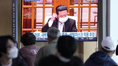 Le leader nord-coréen Kim Jong Un portant un masque passe à la TV, le 14 mai 2022