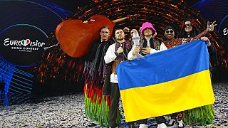 Kalush Orchestra levantando el micrófono de cristal de Eurovisión 2022