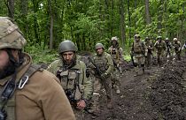 Militares ucranianos caminan por el bosque cerca de un pueblo recientemente retomado, al norte de Kharkiv, en el este de Ucrania, el domingo 15 de mayo de 2022