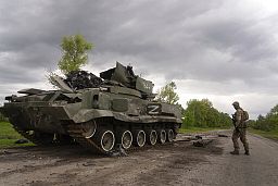 Ukrainian serviceman walks past a blown Russian APC near Kutuzivka, north of Kharkiv, east Ukraine, Sunday, May 15, 2022. Ukrainian serviceman walks past a blown Russian APC near Kutuzivka, north of Kharkiv, east Ukraine, Sunday, May 15, 2022.