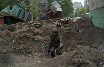 متطوع من الجيش الأوكراني يتفقد موقعًا بعد غارة جوية شنتها القوات الروسية في ليسيشان.