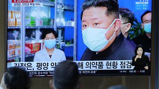 People watch a TV screen showing a news program reporting with an image of North Korean leader Kim Jong Un, at a train station in Seoul, South Korea, Monday, May 16, 2022