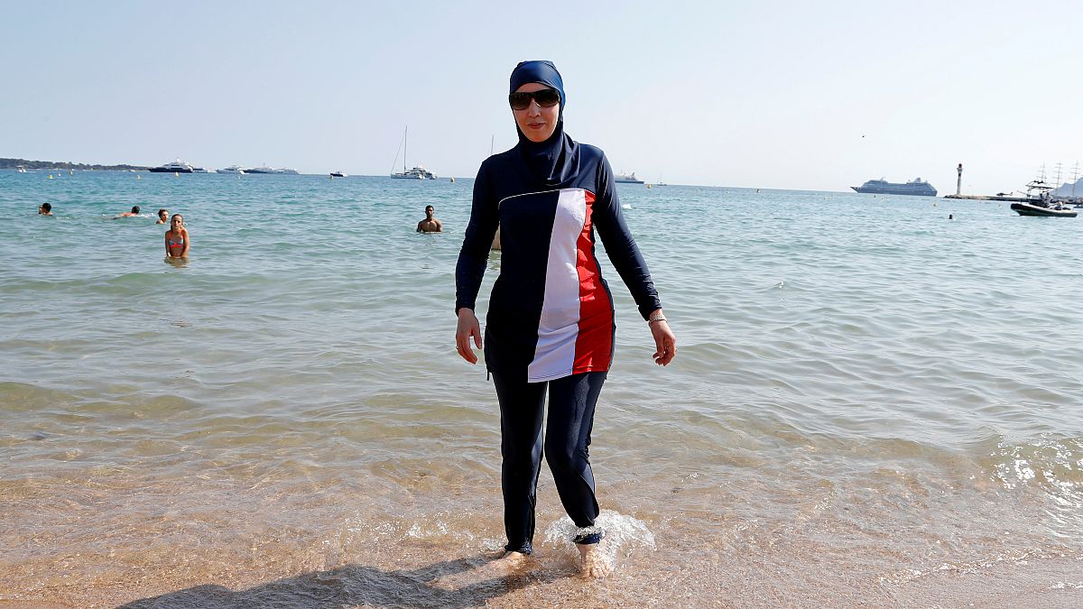 Karima, wearing a full-body burkini swimsuit, walks on a beach in Cannes after the call to support the wearing of burkinis by businessman and political activist Rachid Nekkaz.