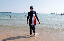 Karima, wearing a full-body burkini swimsuit, walks on a beach in Cannes after the call to support the wearing of burkinis by businessman and political activist Rachid Nekkaz.