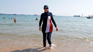 Karima, wearing a full-body burkini swimsuit, walks on a beach in Cannes after the call to support the wearing of burkinis by businessman and political activist Rachid Nekkaz.