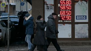 روس يمشون أمام مكتب صرافة في موسكو، روسيا