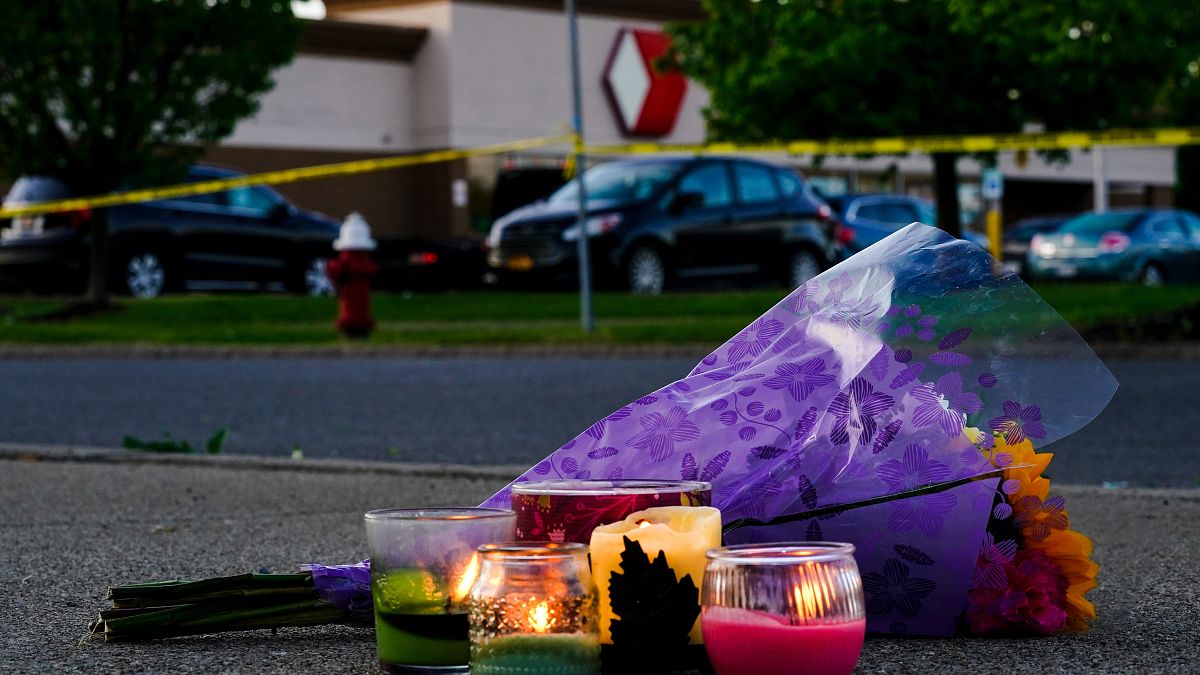 Flowers and candles lay outside the scene of a shooting at a supermarket in Buffalo.