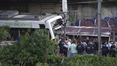 La policía y los trabajadores de rescate permanecen junto a los restos tras un accidente de tren en Sant Boi, cerca de Barcelona, España, el lunes 16 de mayo de 2022