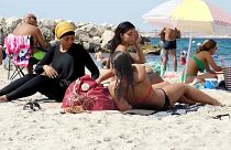 Burkini- und Bikini-Trägerinnen an französischem Strand