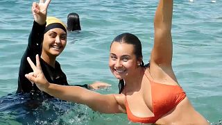 فتاتان يسبحان في شاطئ فرنسي إحدهما ترتدي البوركيني