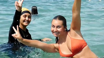 فتاتان يسبحان في شاطئ فرنسي إحدهما ترتدي البوركيني 