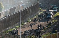  قوات الأمن على الجانب المغربي من الحدود أمام السياج الفاصل بين جيب مليلية الإسباني والمغرب، في مليلية، إسبانيا، مارس 2022.