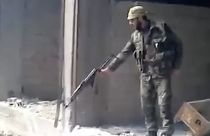 صورة مأخوذة من مقطع صوّر في العام 2013، تظهر جندياً سورياً يطلق النار على حفرة كبيرة مليئة بالجثث، في حي التضامن بدمشق، سوريا.