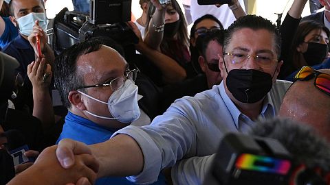 Presidential candidate Rodrigo Chaves greets supporters as he arrives to a polling station during a presidential runoff election in San Jose, Costa Rica, April 3, 2022.