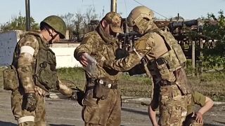 جنود روسيون يقومون بتفتيش جندي أوكراني بعد استسلامه 17/05/2022