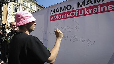 أوليه بسيوك ، قائد أوركسترا كالوش الأوكرانية ، الفائز في مسابقة الأغنية الأوروبية ، يوقع على جدار الأسماء لإطلاق حملة #MomsOfUkraine، في لفيف، أوكرانيا، الثلاثاء 17 مايو2022