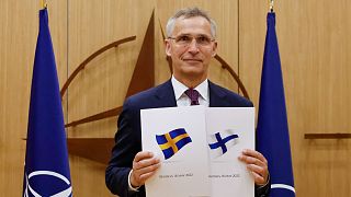 NATO Secretary-General Jens Stoltenberg displays documents as Sweden and Finland applied for membership in Brussels, Belgium, Wednesday May 18, 2022