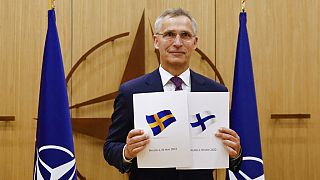 NATO Secretary-General Jens Stoltenberg displays documents as Sweden and Finland applied for membership in Brussels