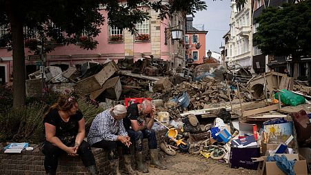 Victims survey the wreckage after a flood in Germany, climate events like this will be more common thanks to global heating