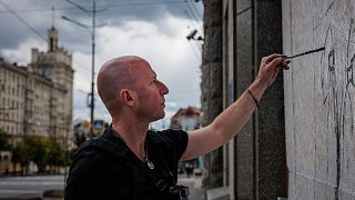 Le street artist Gamlet Zinkivsky peignant dans sa ville de Kharkiv 