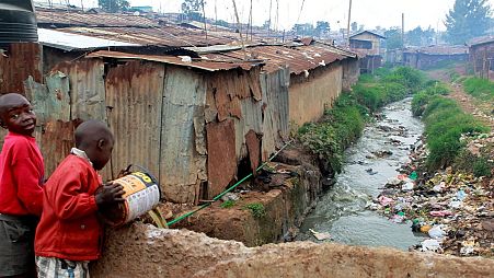 A boy disposes of raw sewage into a stream in the sprawling Kibera slum in Kenya's capital of Nairobi.