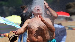 Un homme se rafraichit sous une douche de plage, Biarritz, France, le 18 mai 2022