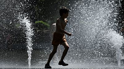A child cools off in a fountain in Toulouse, southern France, on May 18, 2022