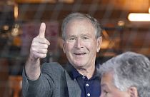 Former President George W. Bush gives a thumbs-up before a baseball game between the Atlanta Braves and the Texas Rangers in Arlington, Texas, Sunday, May 1, 2022.
