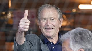 Former President George W. Bush gives a thumbs-up before a baseball game between the Atlanta Braves and the Texas Rangers in Arlington, Texas, Sunday, May 1, 2022.